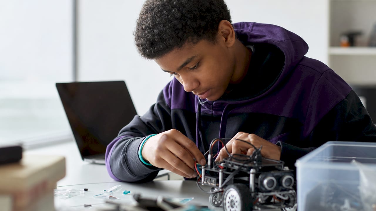 Child hands assembling small electrical circuit