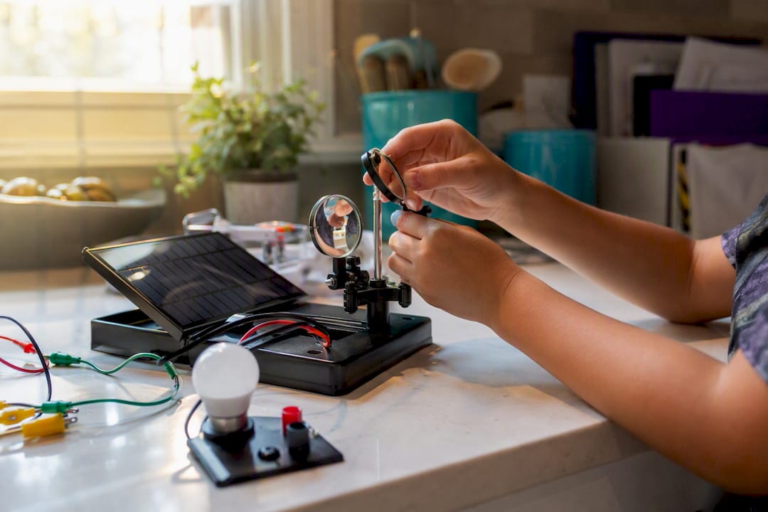 Child hands adjusting solar experiment components