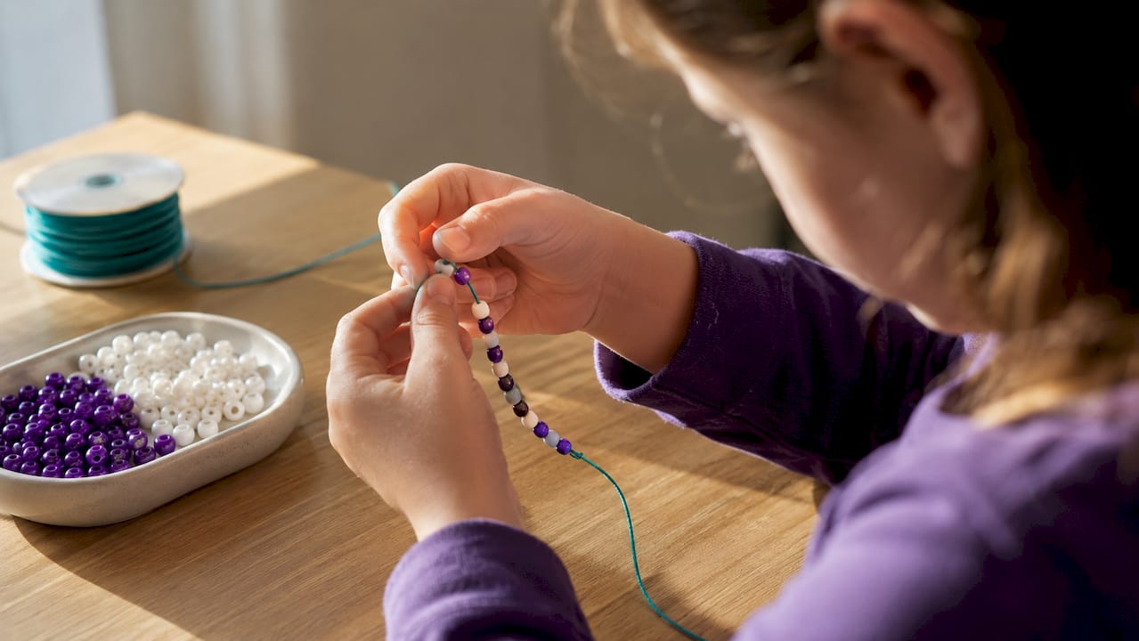Child threading a binary bead bracelet