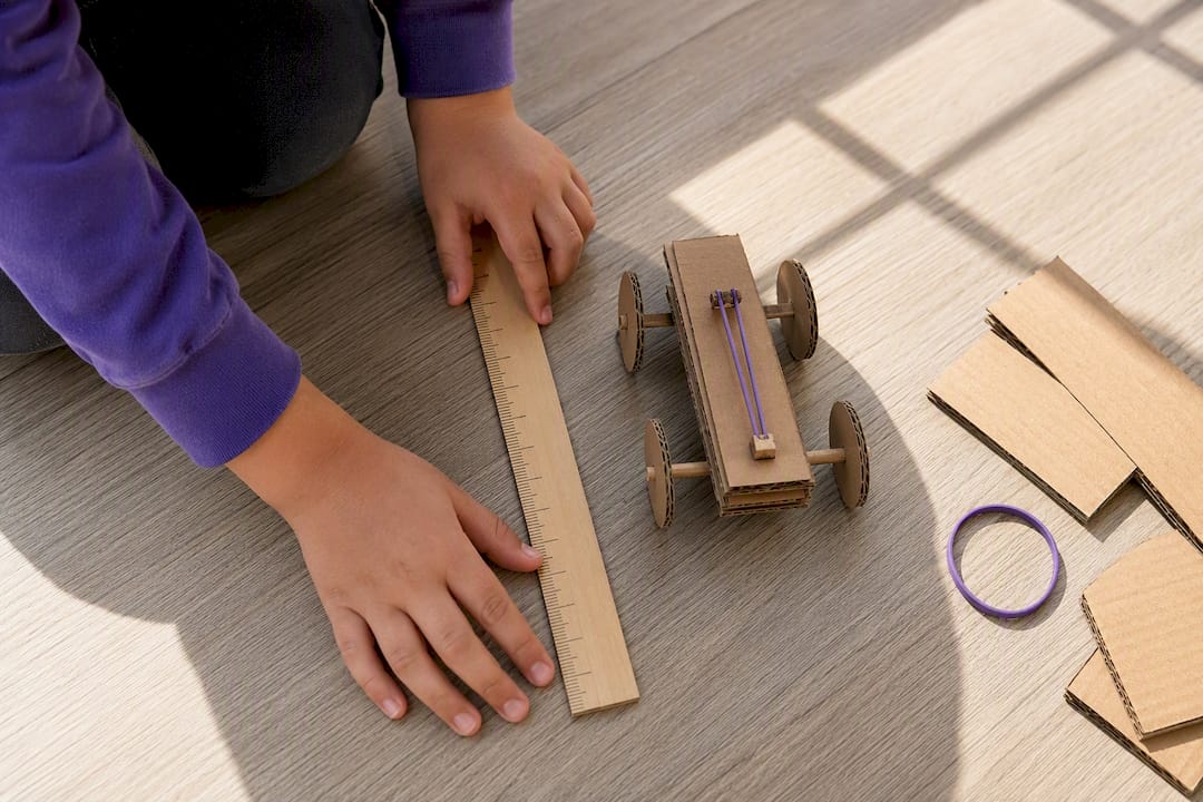 Hands measuring cardboard rover distance