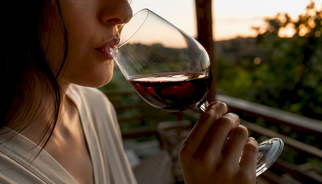 Person sipping wine, close-up mouth and glass