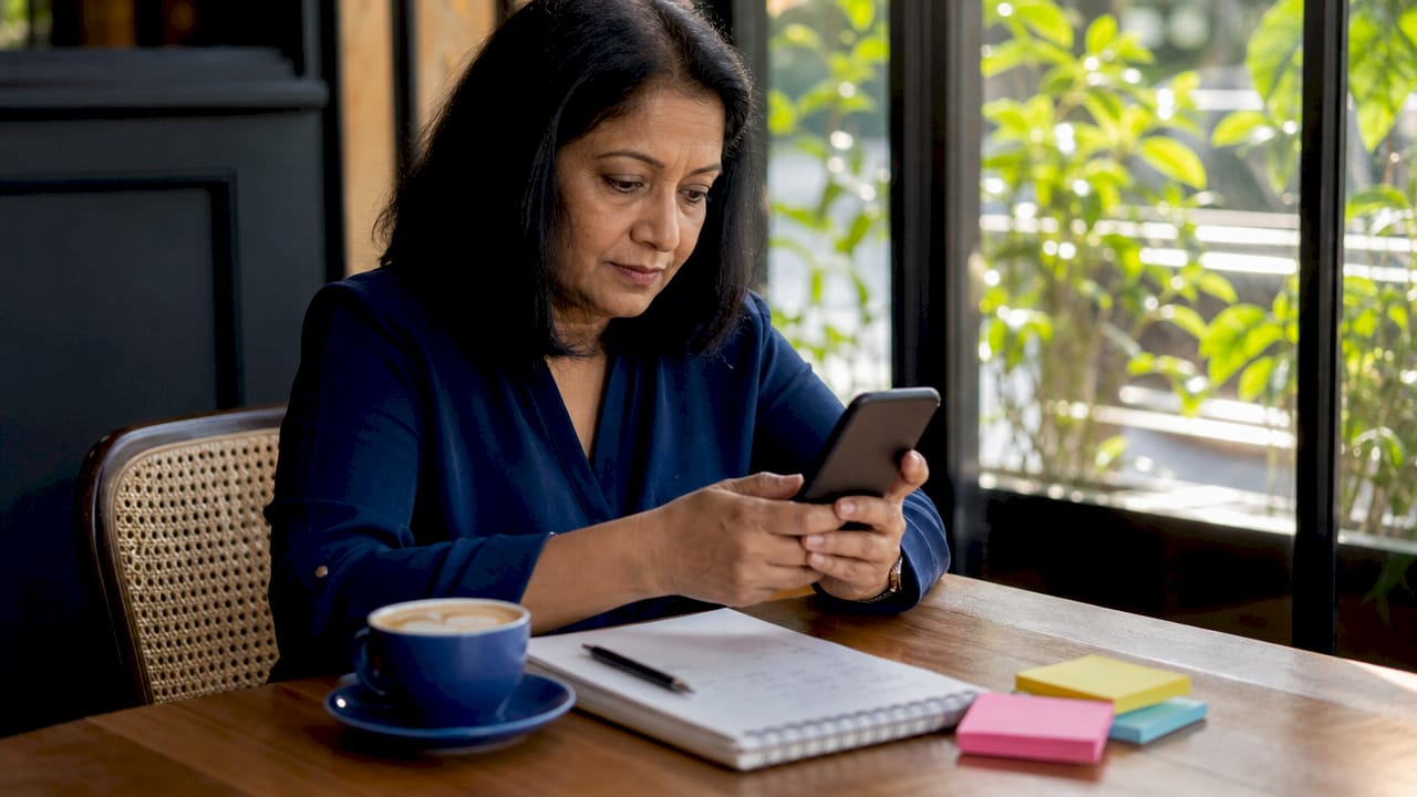 Woman evaluating smartphone content at home table