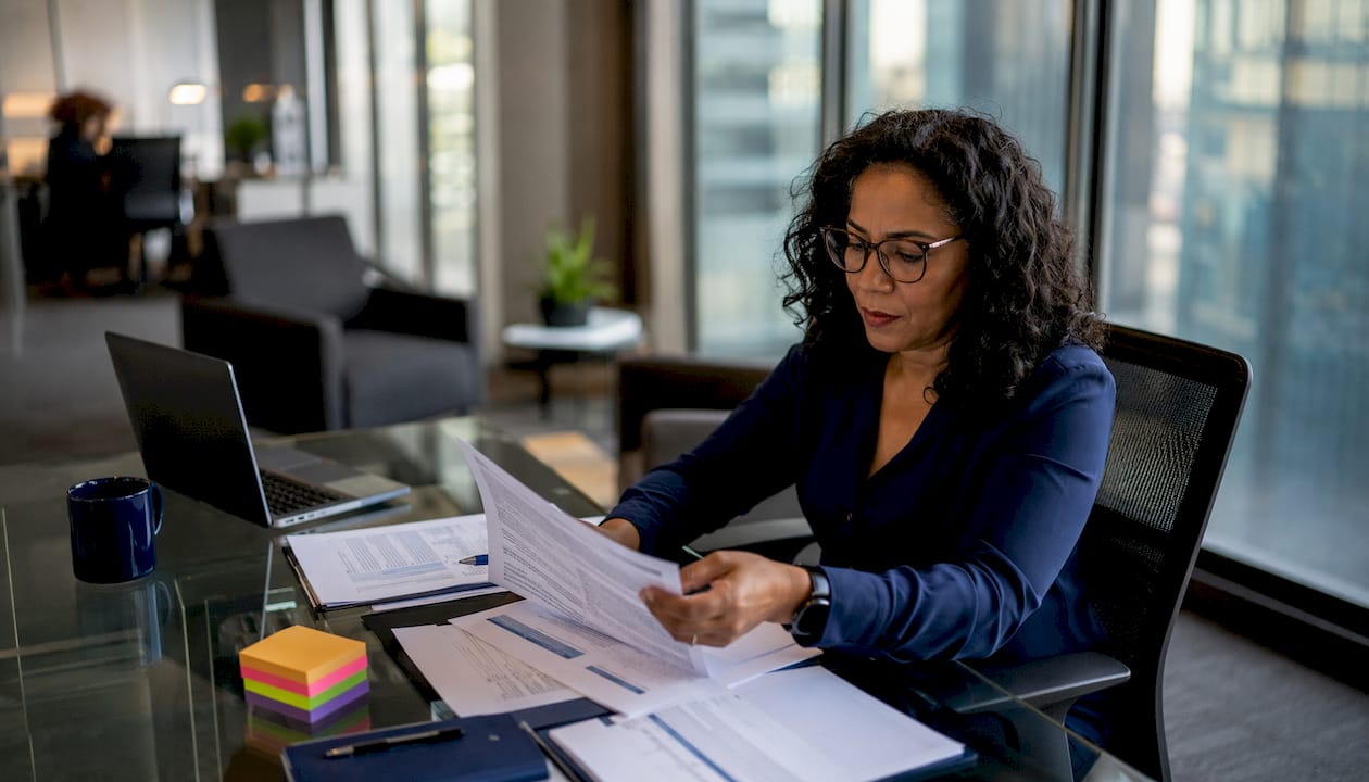 Woman reviewing cybersecurity documents at desk