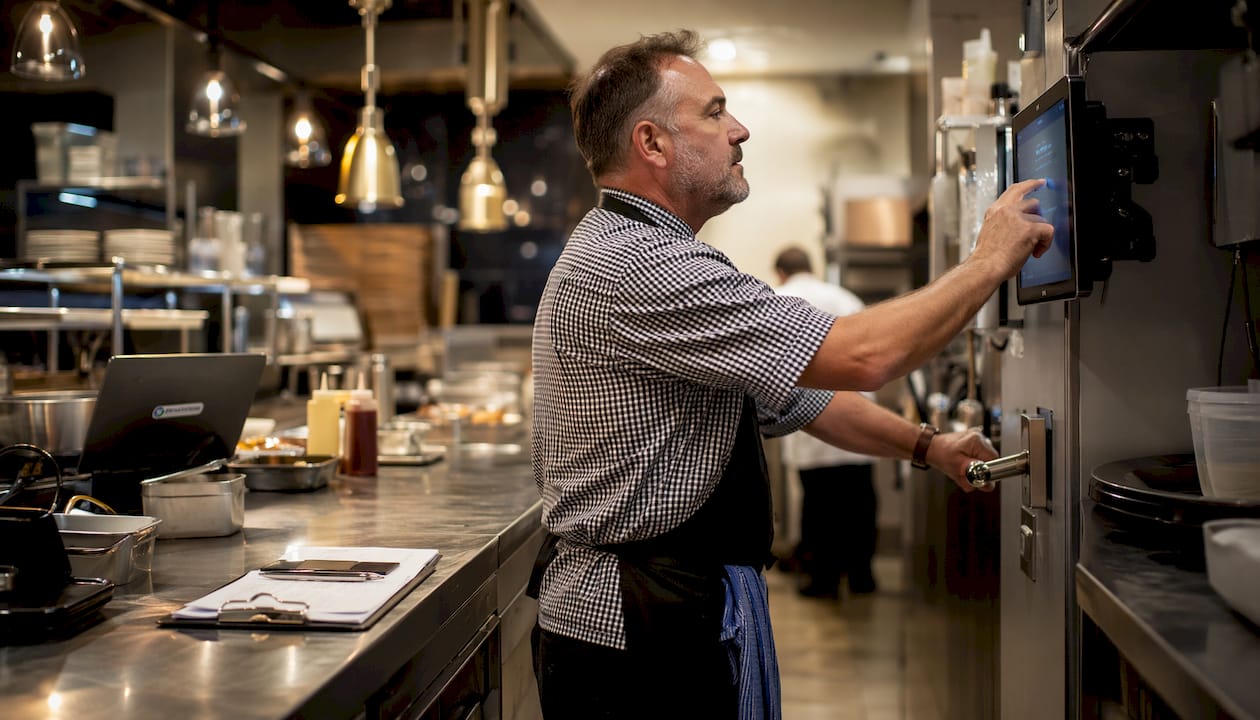 Chef using touchscreen and bump bar in kitchen