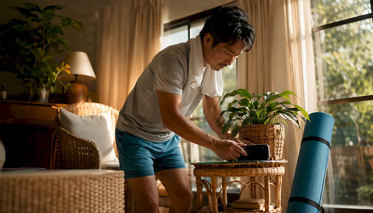 Man adjusting alarm clock in serene bedroom morning