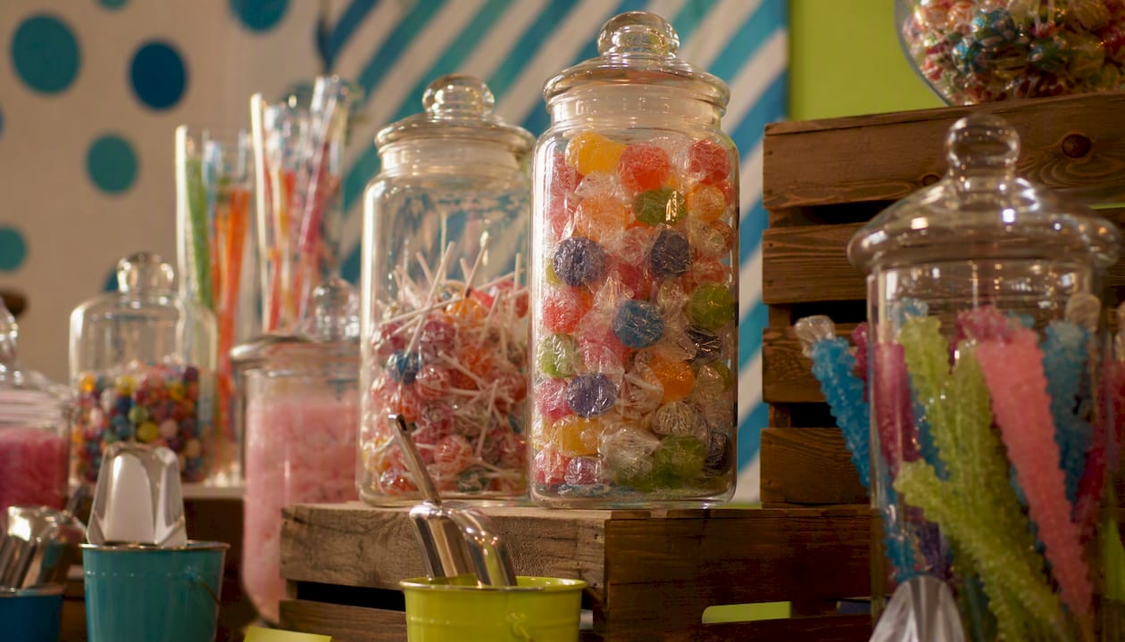 Tall jars with wrapped candies on buffet back zone
