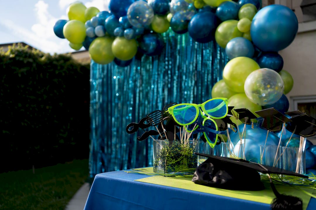 Metallic graduation backdrop with balloon garland and props