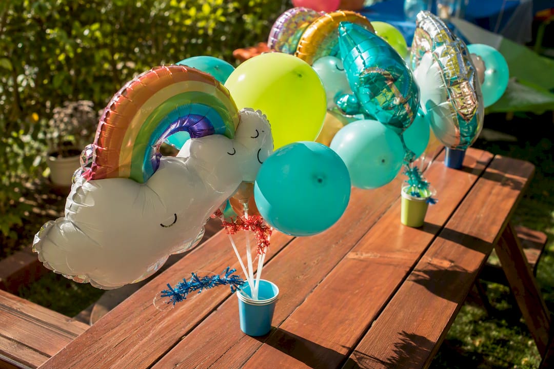 Air-filled balloons on sticks and garlands at party table