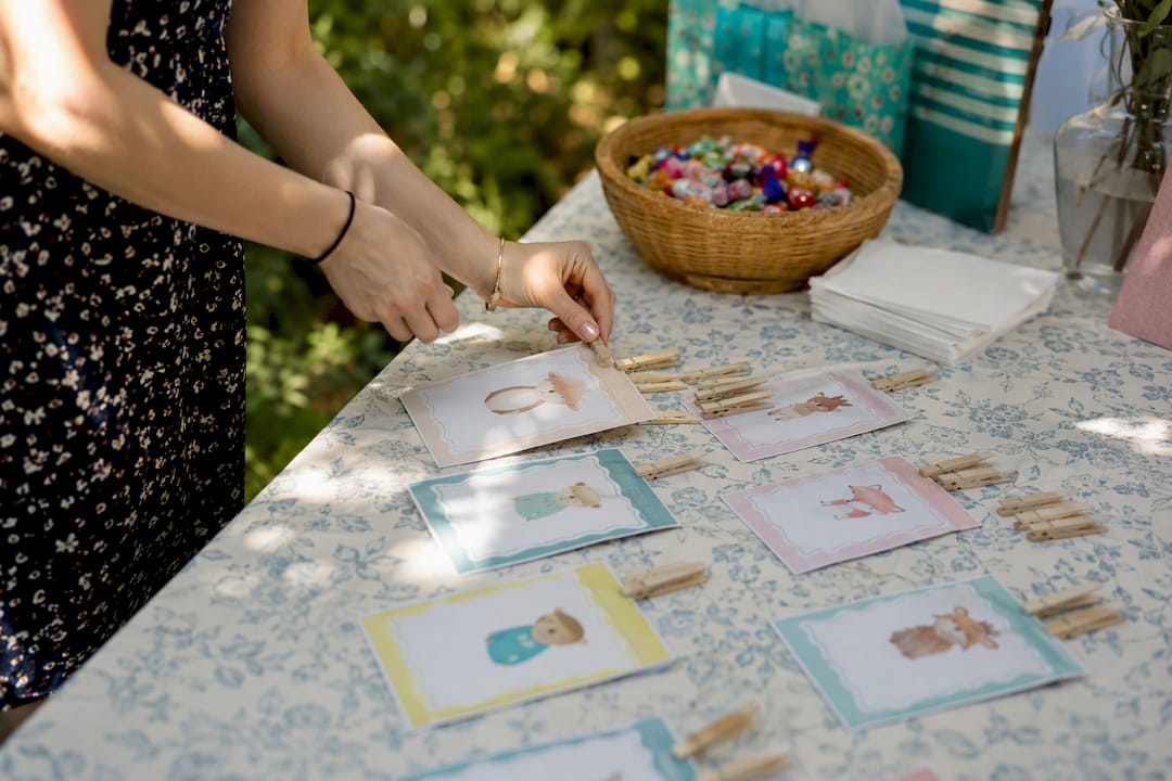 Hands setting up baby shower games on table