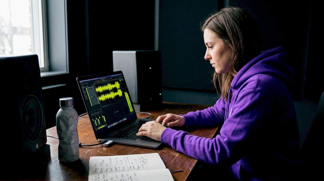 Engineer trimming audio track in studio