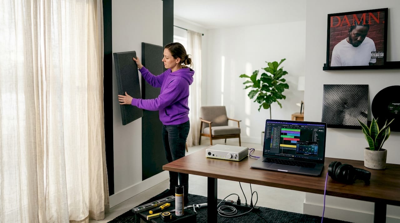 Person installing foam panels in home studio
