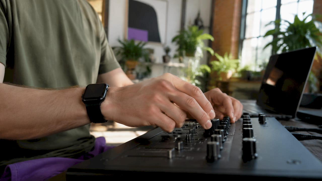 Close-up hands adjusting audio buffer size knob