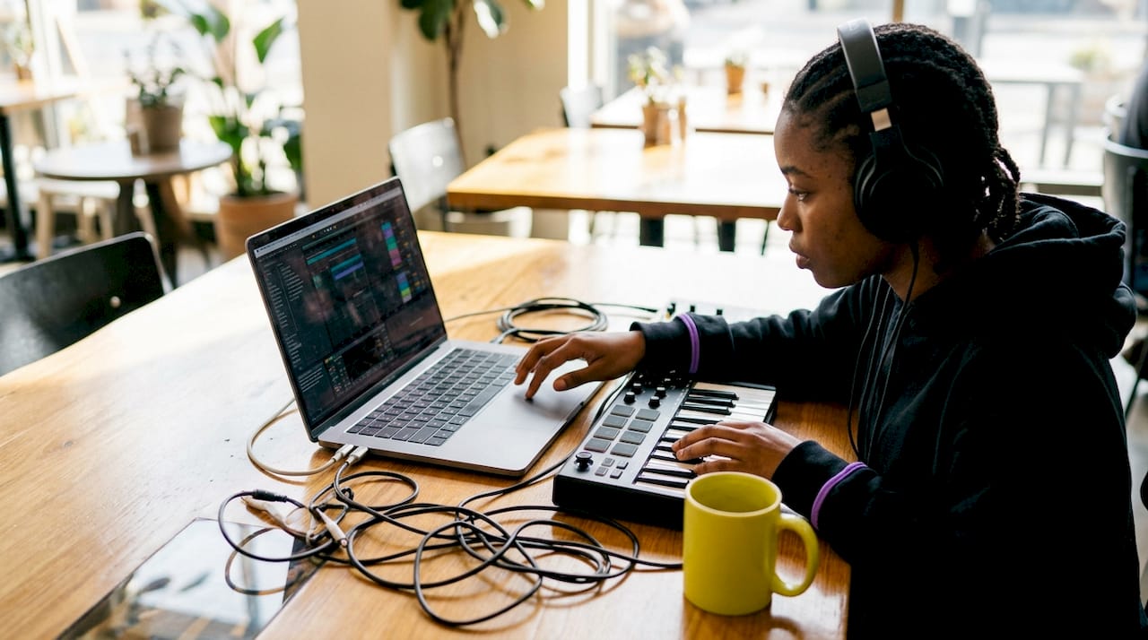 Music producer adjusting clip gain on laptop