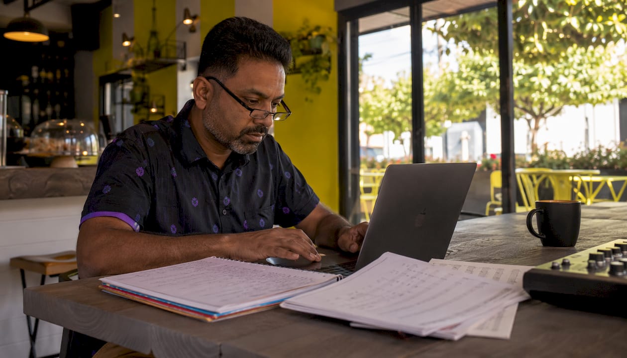 Educator using GarageBand on MacBook at home