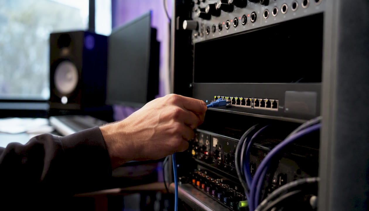 Hand plugging Ethernet cable into network switch