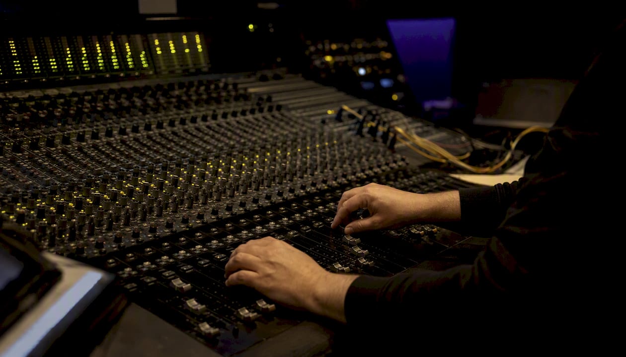 Hands on mixing console in professional studio