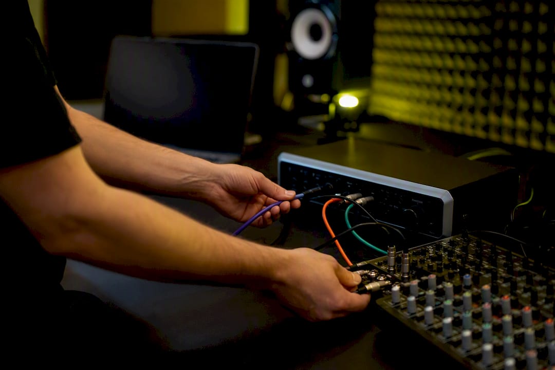 Hands connecting audio cables in modern studio