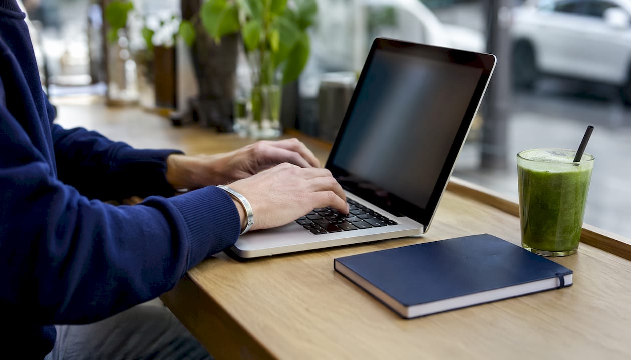 Hands typing on laptop researching property investment