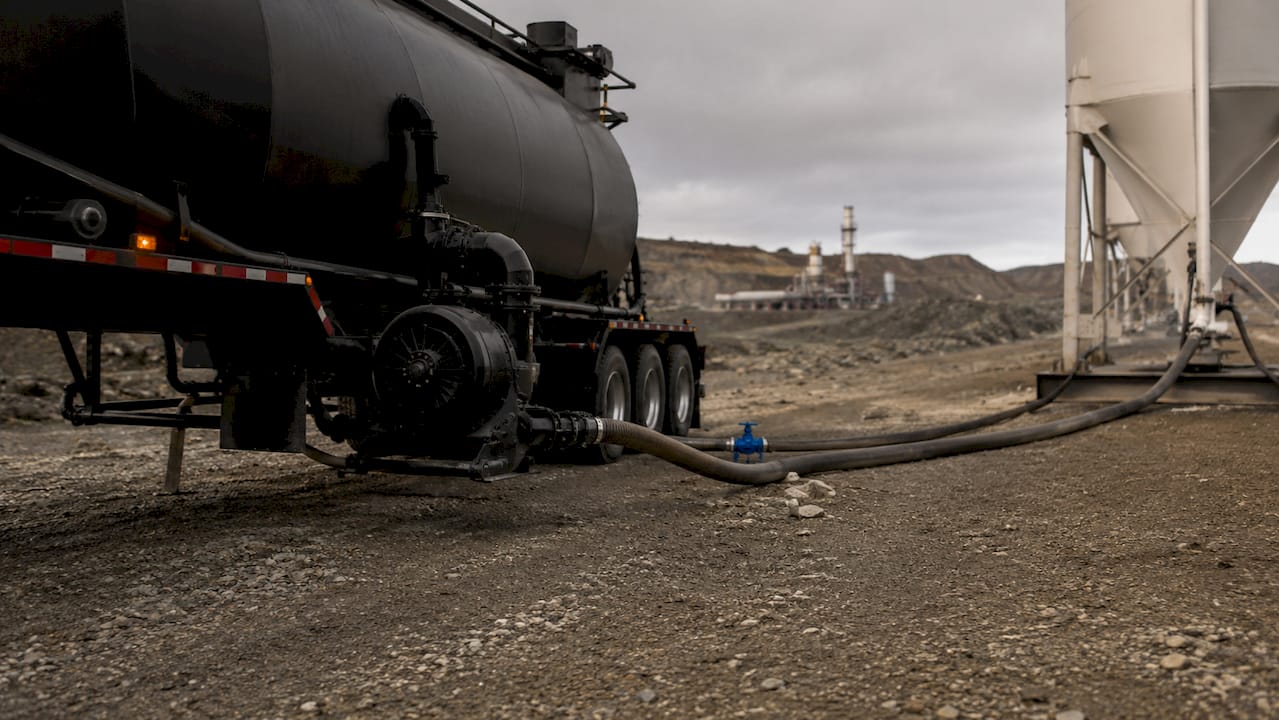 Close-up of pneumatic trailer discharge setup at drilling site