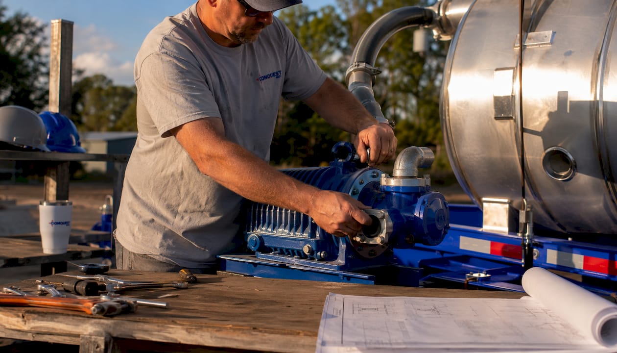 Technician assembling liquid waste hauling trailer parts