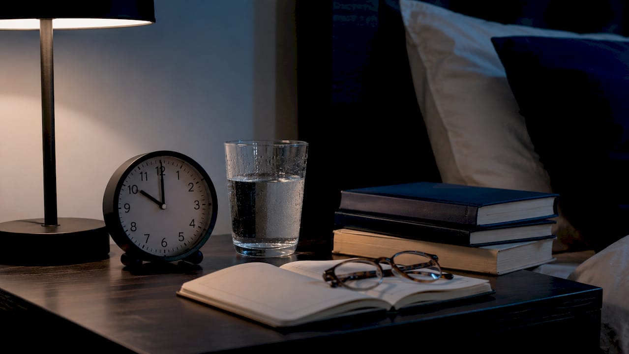 Top-down view of bedside table with clock and books