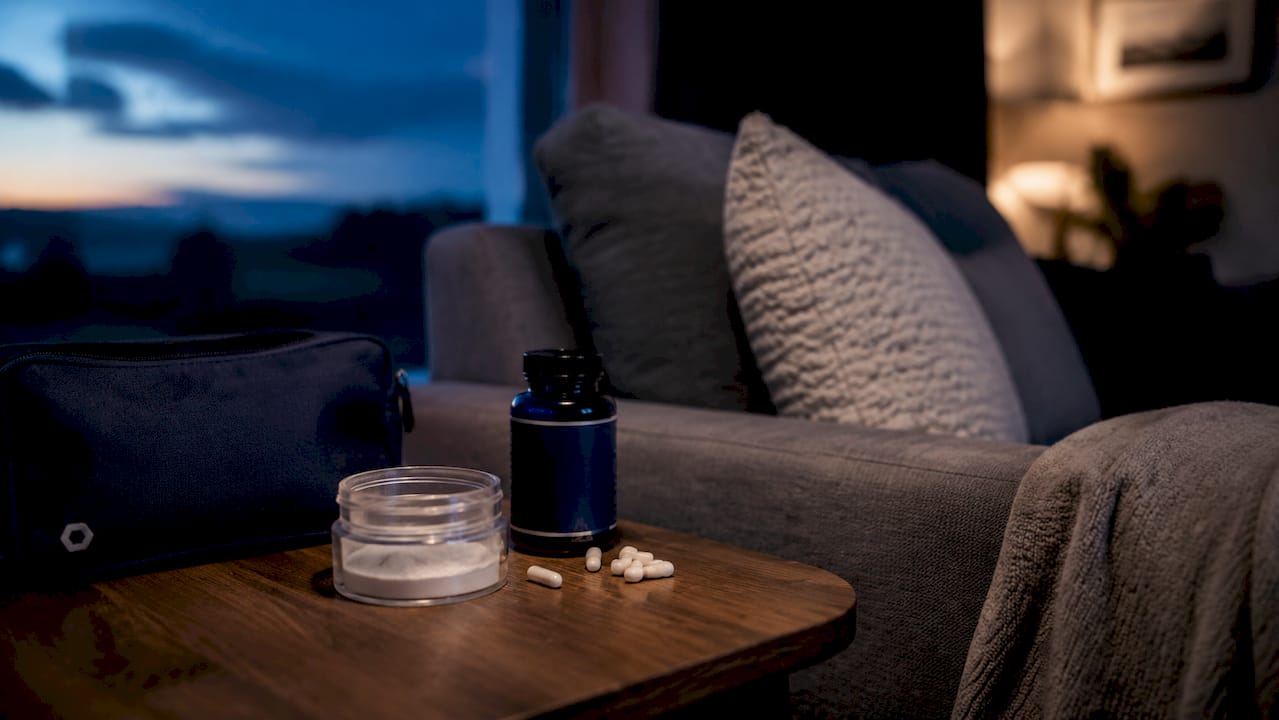 Close-up of sleep supplement bottles on bedside table