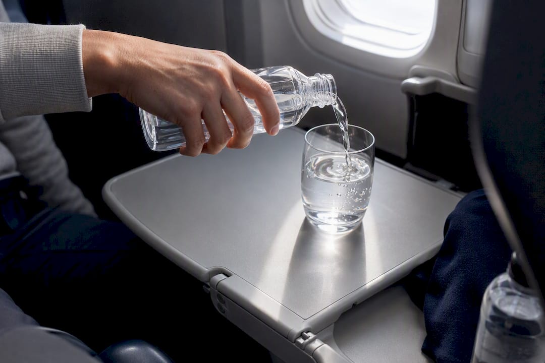 Traveler pouring water during a flight