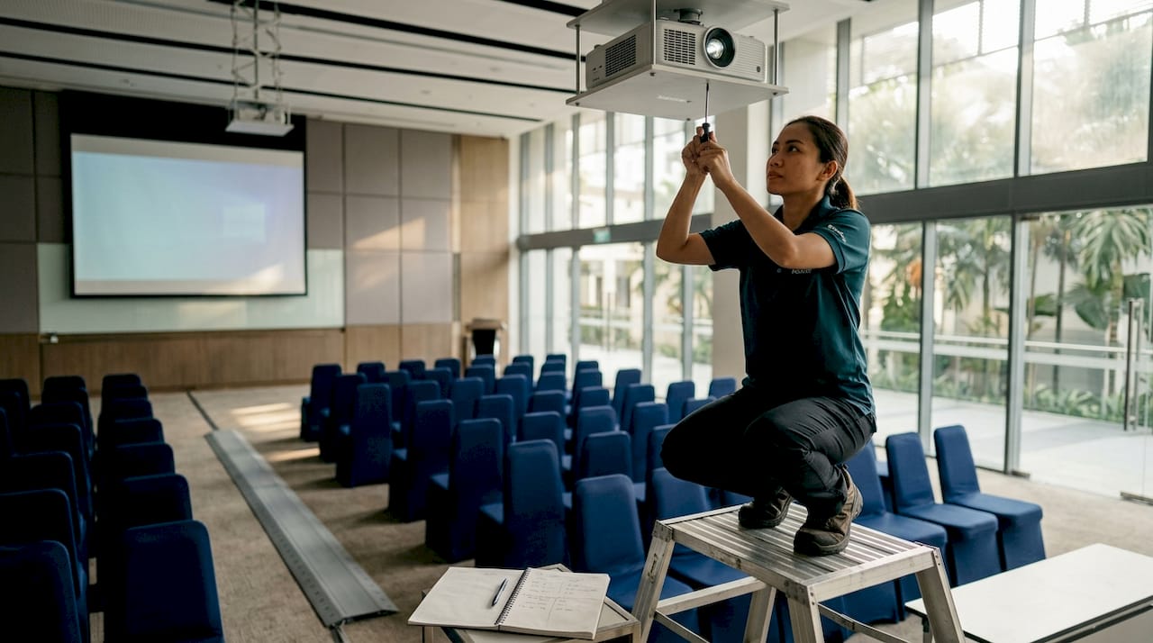 Manager adjusting projector in business hall
