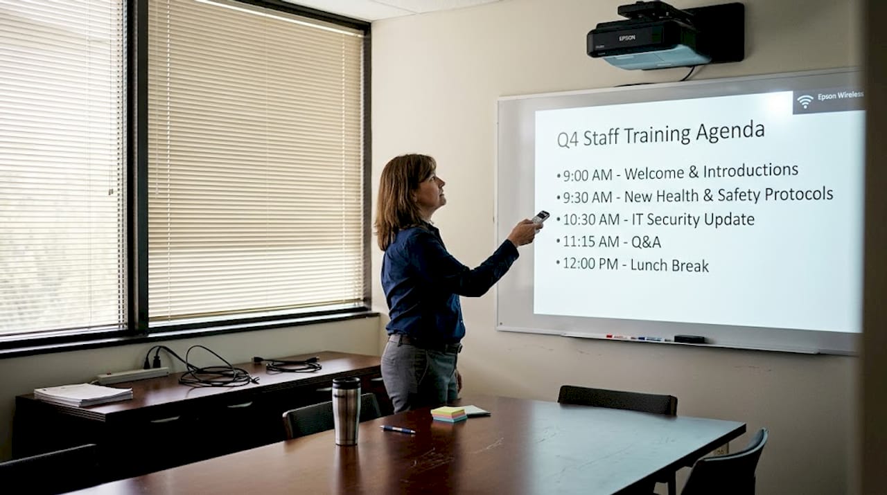 Manager adjusting Epson wireless projector in boardroom