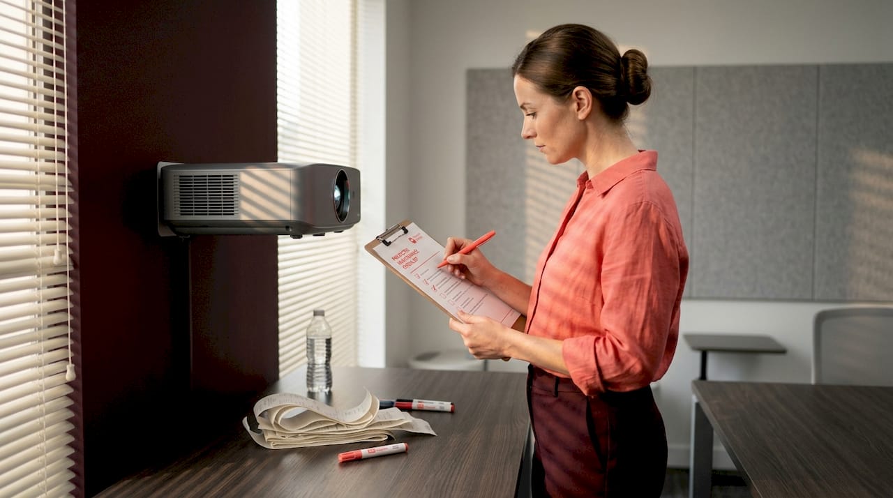 Worker checking projector maintenance checklist
