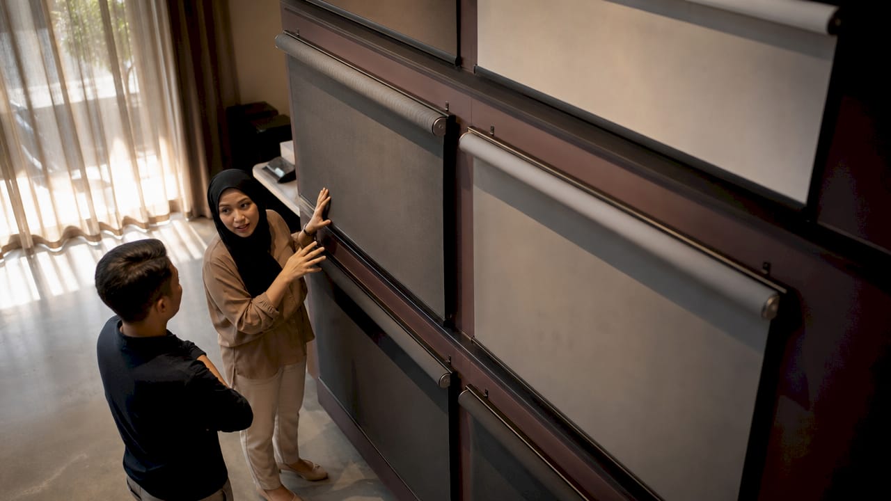 Consultant presenting projection screen fabrics in showroom