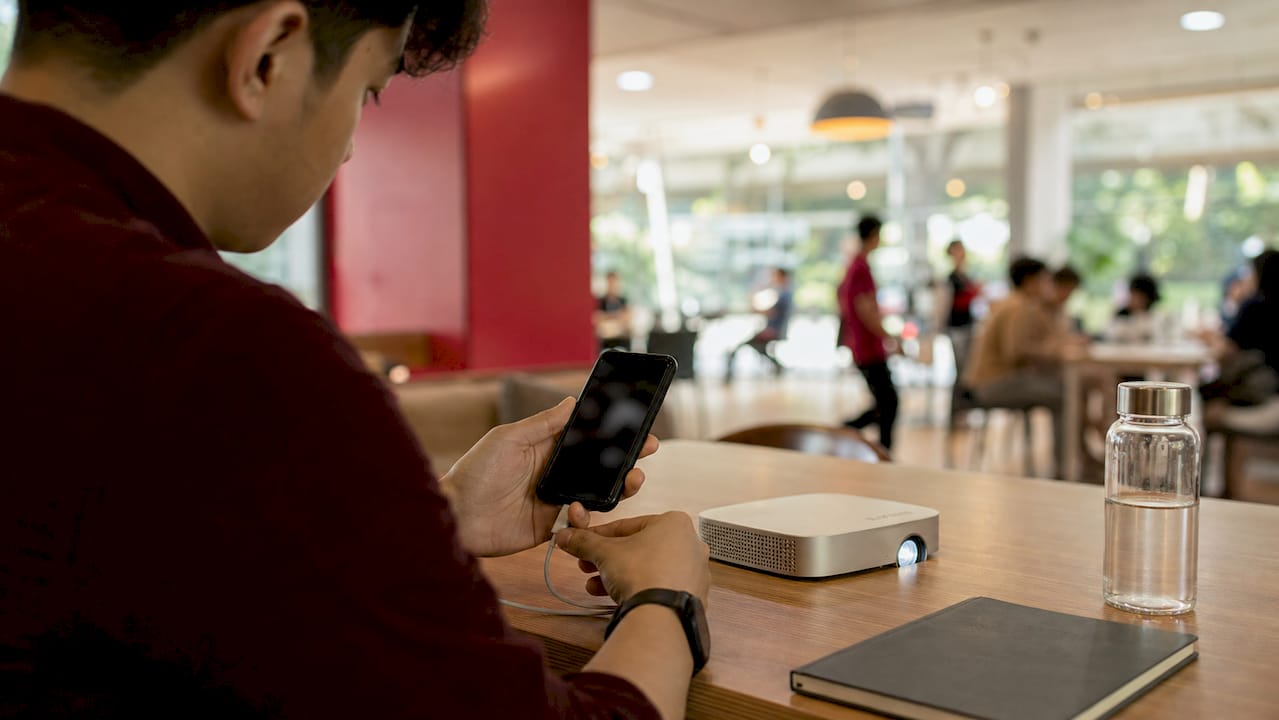 Hands connecting smartphone to wireless projector
