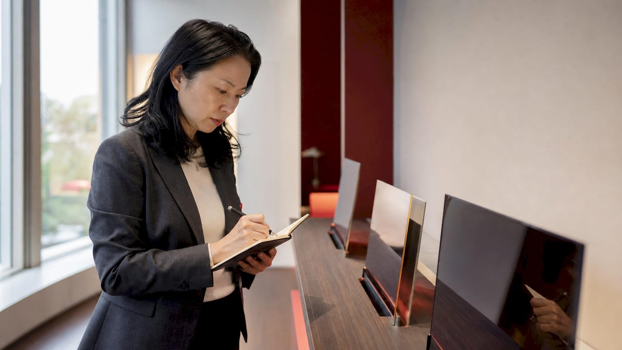 Seorang penyelidik wanita sedang menjalankan kajian ke atas panel OLED di tempat kerjanya.
