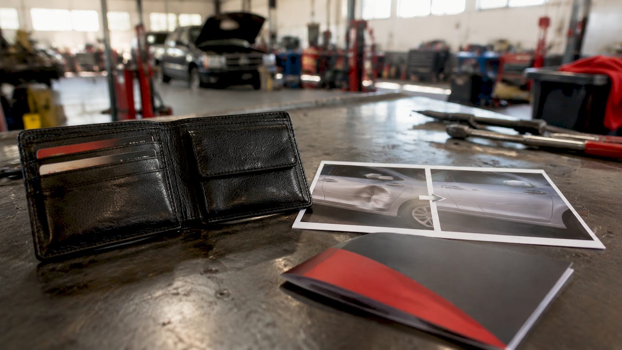 Dent Repair Financing Options Guide for Car Owners 1 Wallet And Dent Repair Financing Materials On Desk