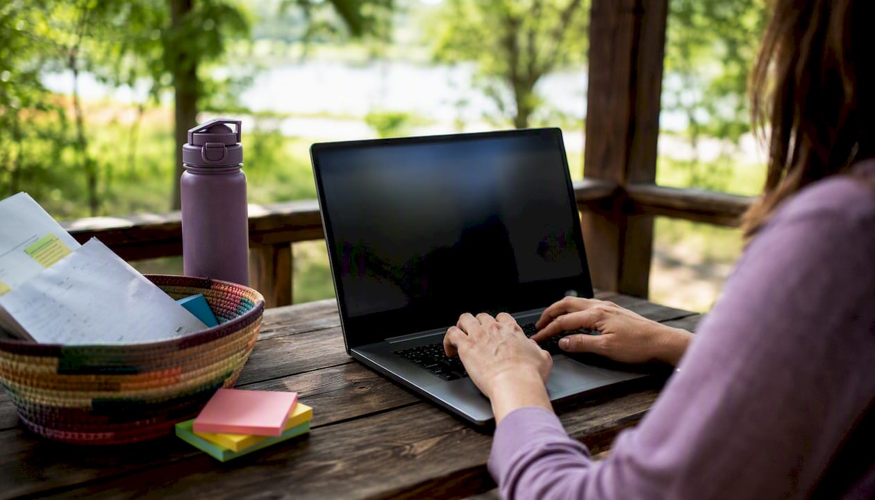 Hands typing and reviewing AI content on laptop