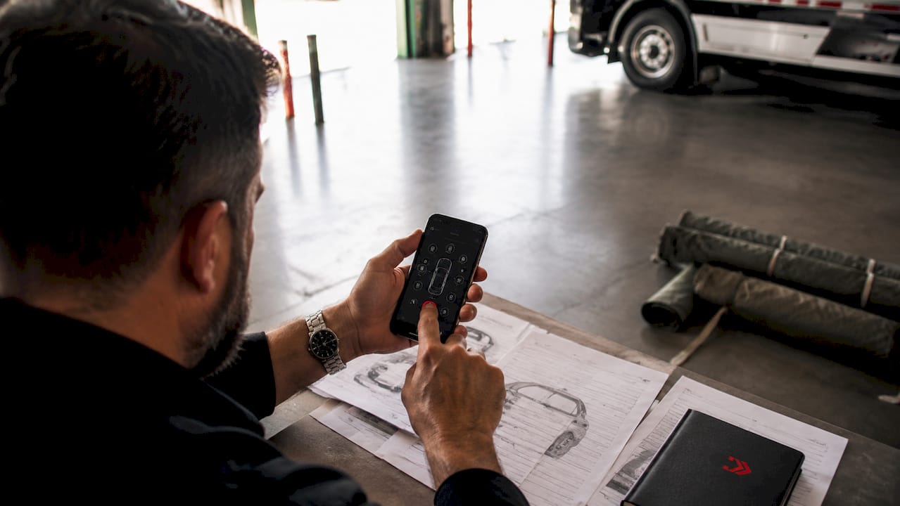 Hands using vehicle sensor app in truck cabin
