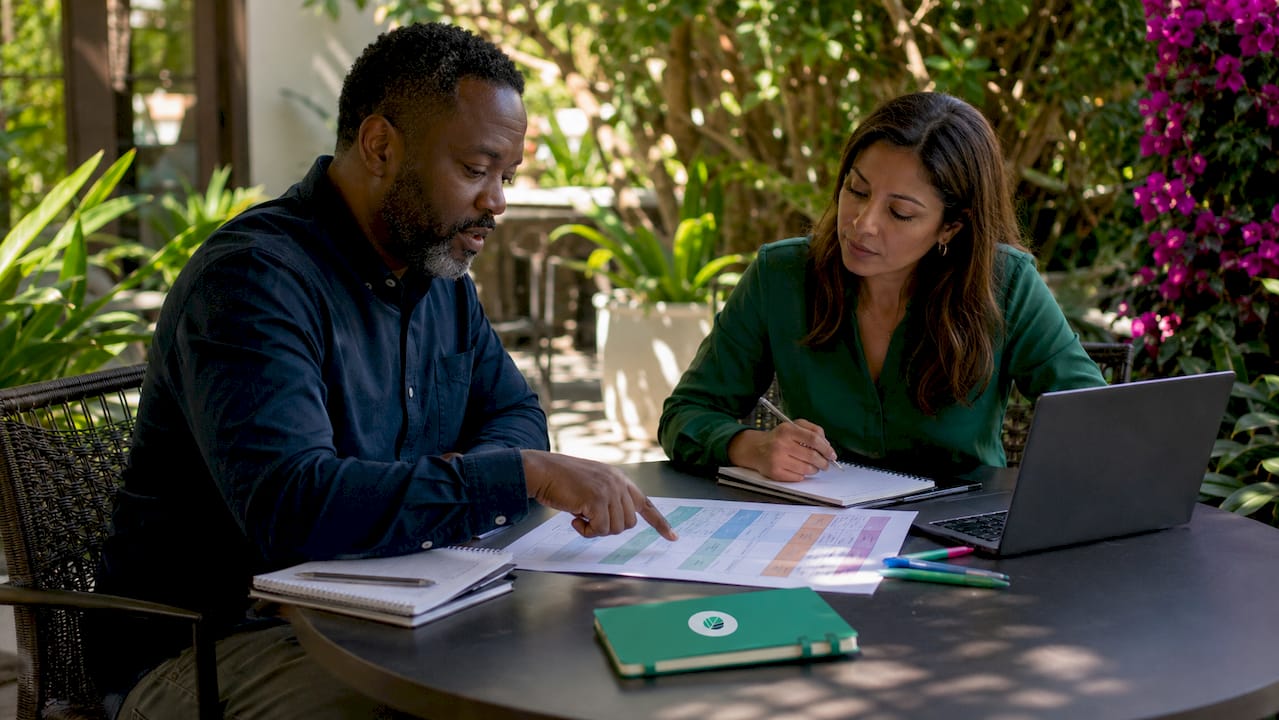 Two professionals collaborating with spreadsheet