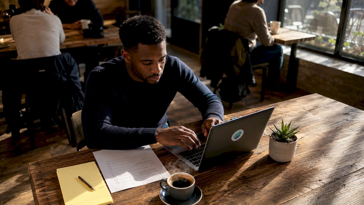 Manager typing feedback notes at coworking desk