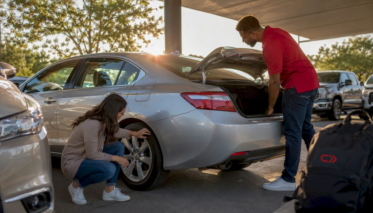Couple inspecting staged car for sale