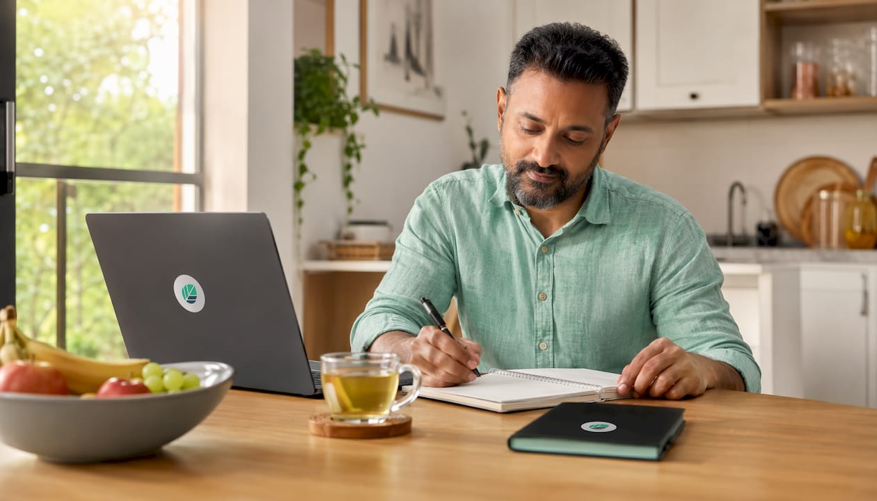 Man jotting notes in home office workspace