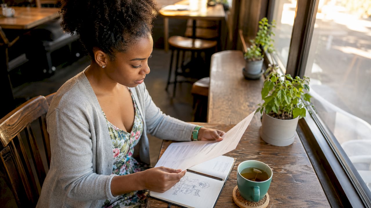 Woman checking student loan status online at kitchen table