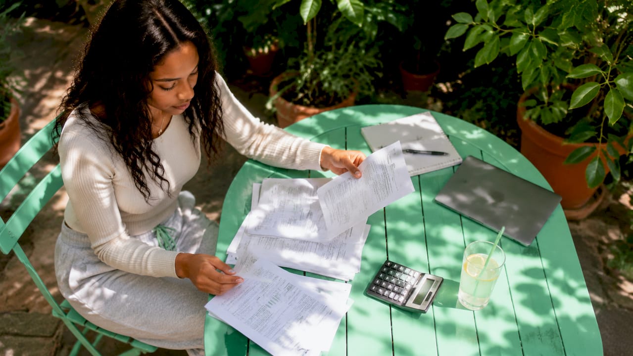Young woman reviewing student loan documents at table