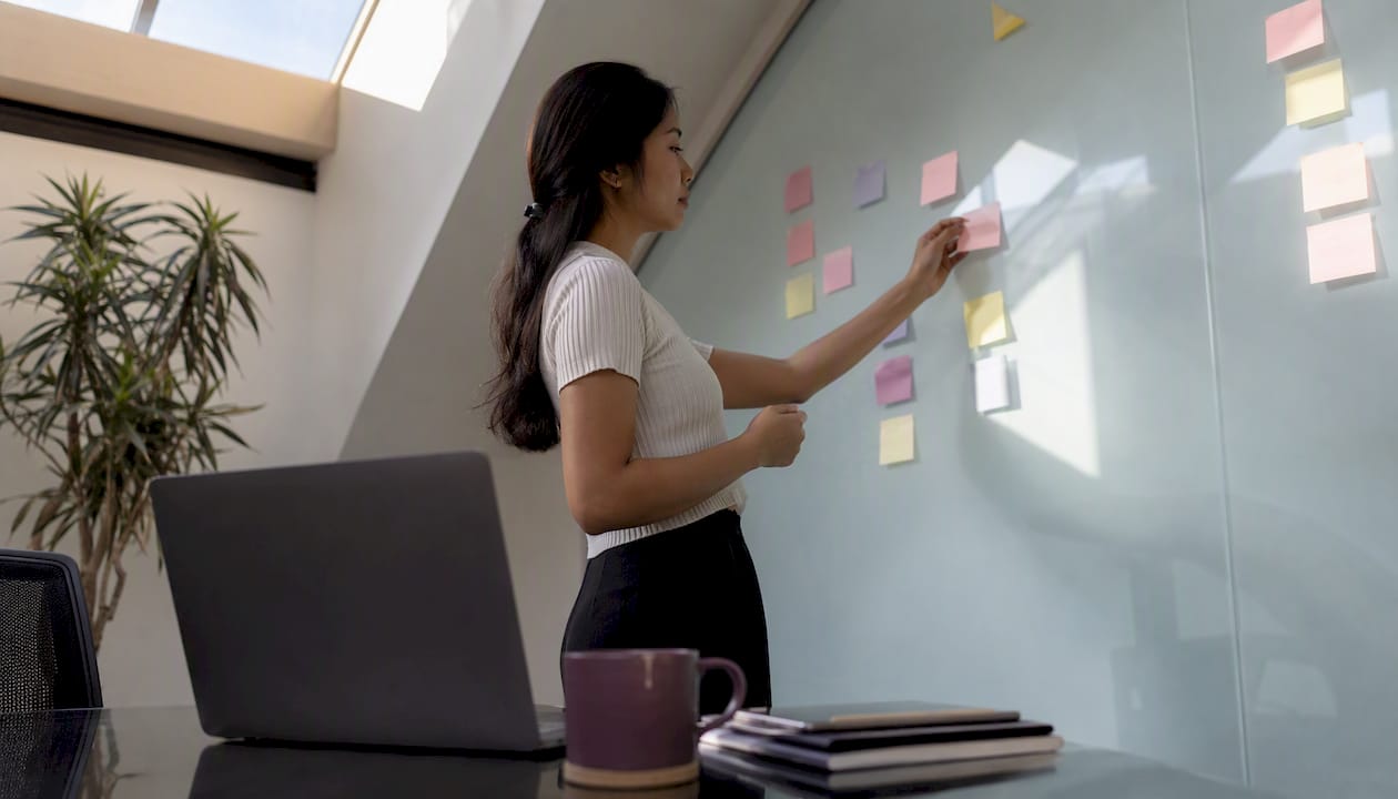 Person placing notes in office task board