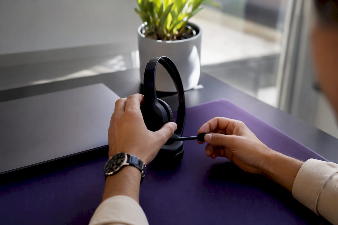 Hands adjusting headset on remote workspace