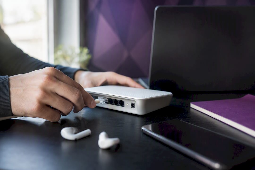 Hands plugging ethernet cable at home office desk