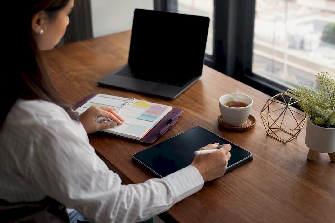 Hands organizing tablet task list at home office desk