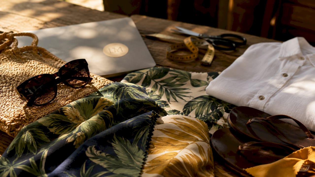Flat lay of tropical print fabrics and vacation accessories