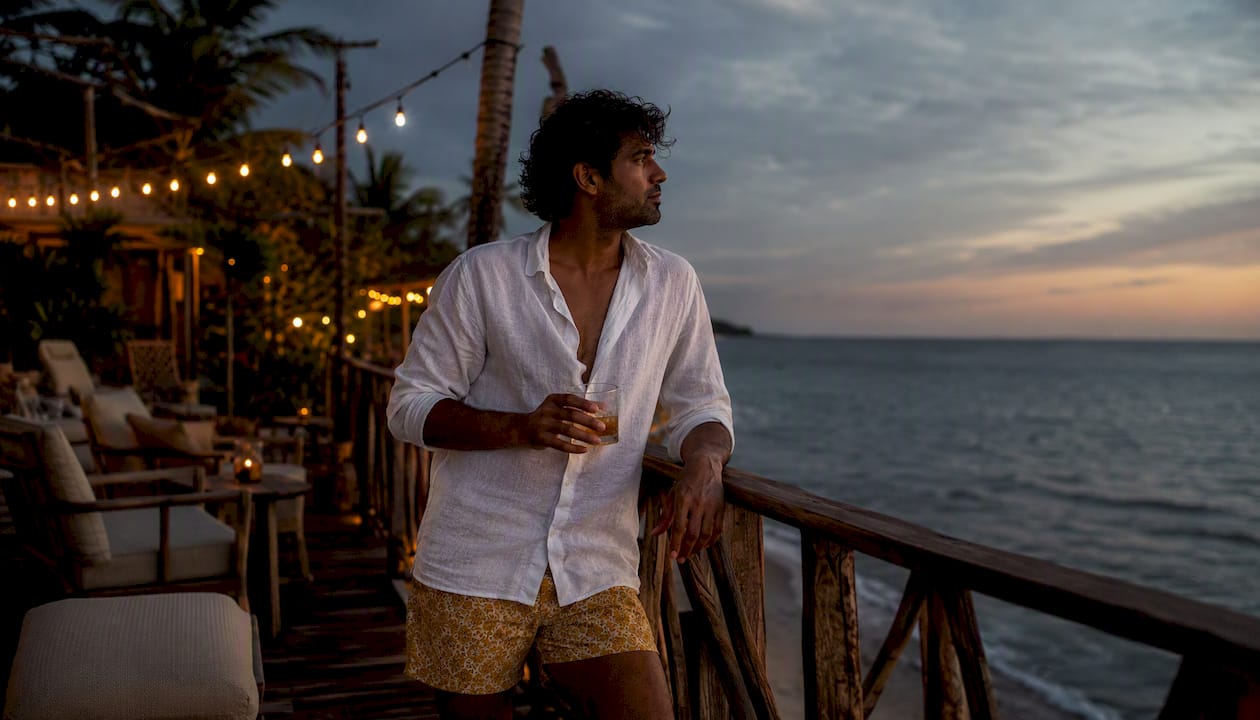 Man wearing swim trunks and fitted tee on rooftop