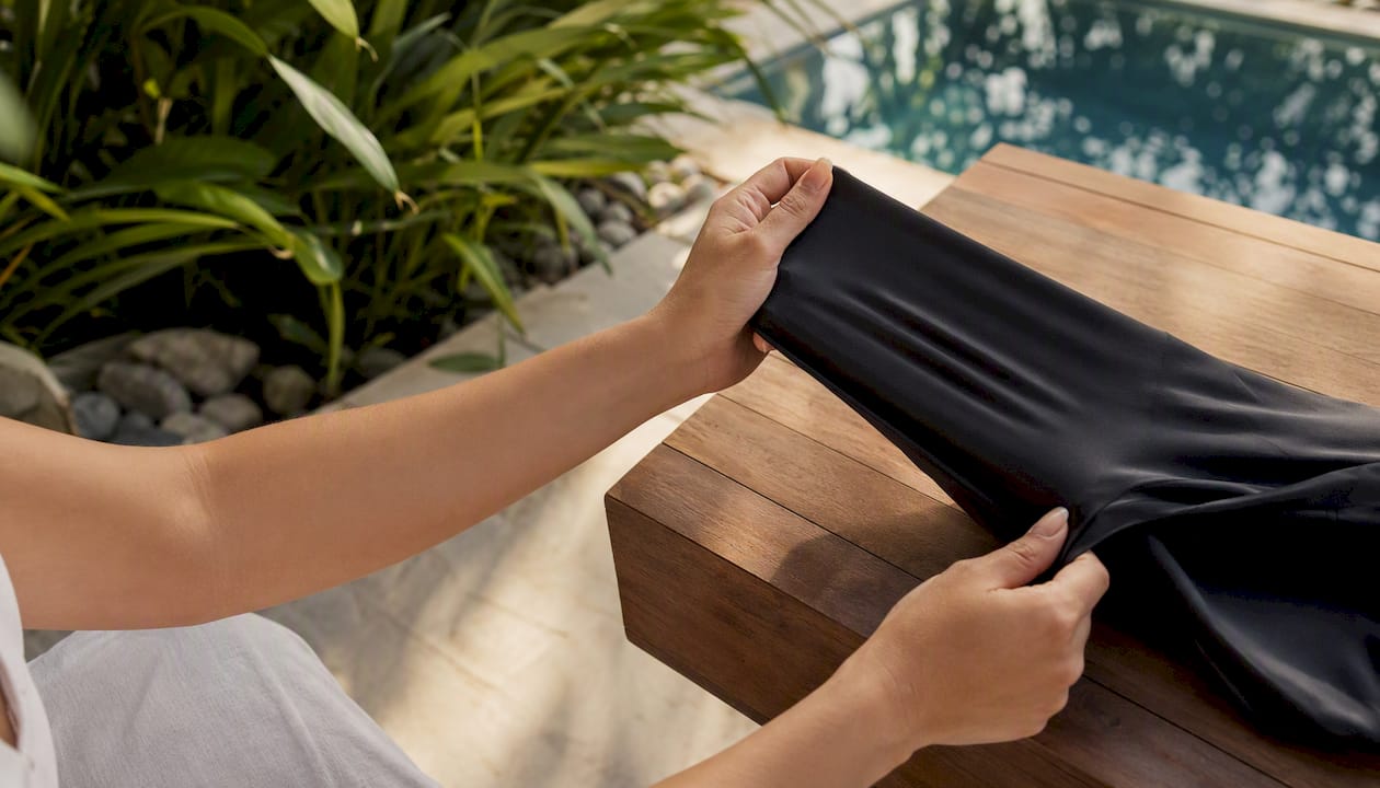 Hands stretching polyester PBT swimwear fabric