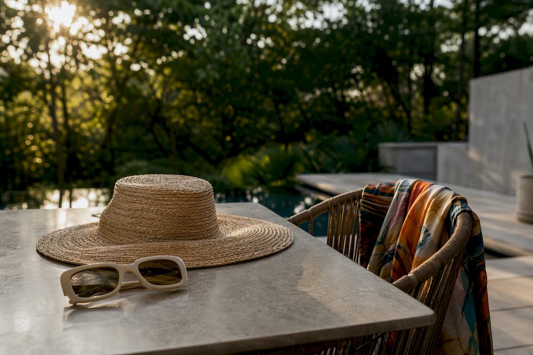 Wide-brim hat and oversized sunglasses on bench
